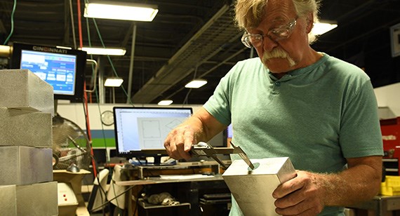 engineer measuring bend accuracy with caliper during sheet metal quality process